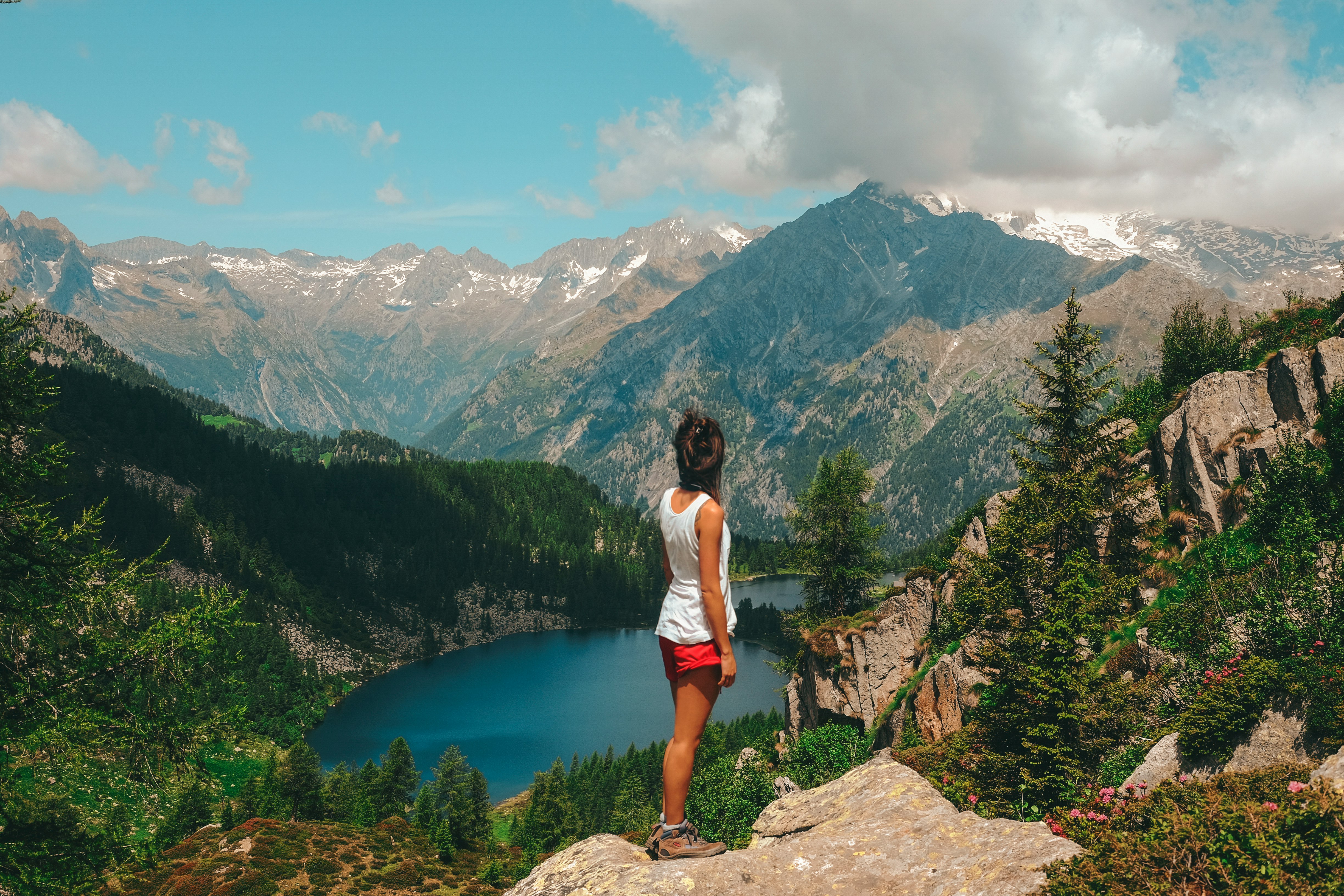 woman standing on rock on top of mountain